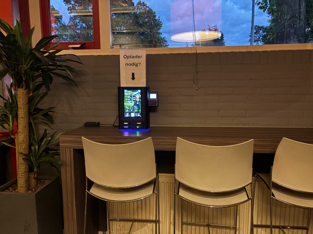 ChargeHero 4-slotsstation aan de bar bij Voetbalclub BFC Bussum, met het bord Oplader nodig?